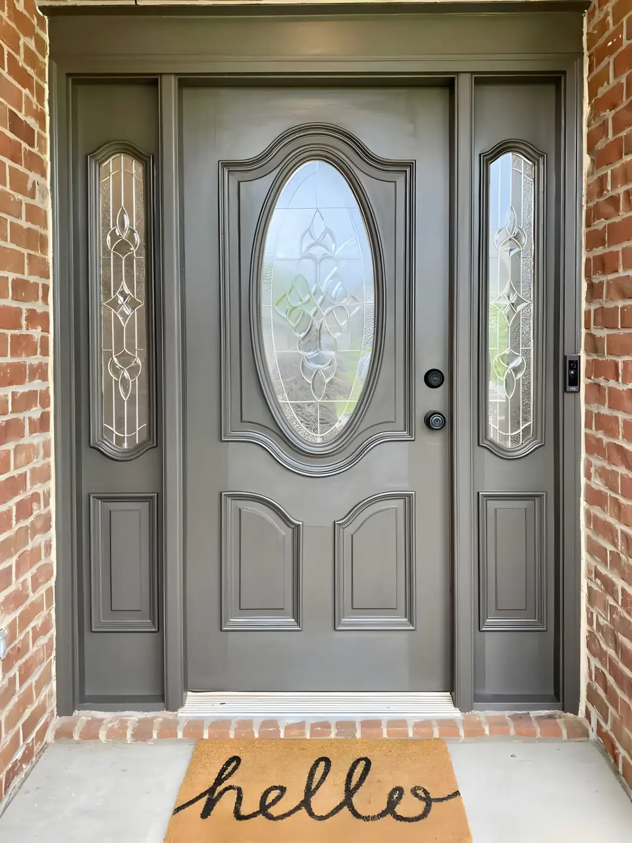 Front door painted warm gray with leaded-glass sidelights, set in brick, the kind of detail that shapes a Belle Meade exterior painting estimate