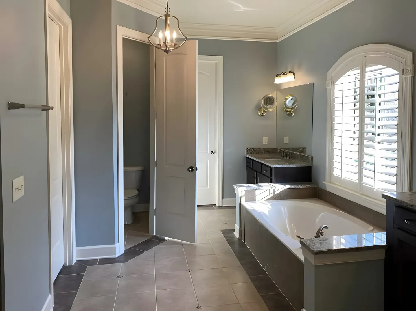 Primary bathroom with blue-gray walls, painted doors and white crown molding, the kind of detail that shapes a Belle Meade interior painting estimate