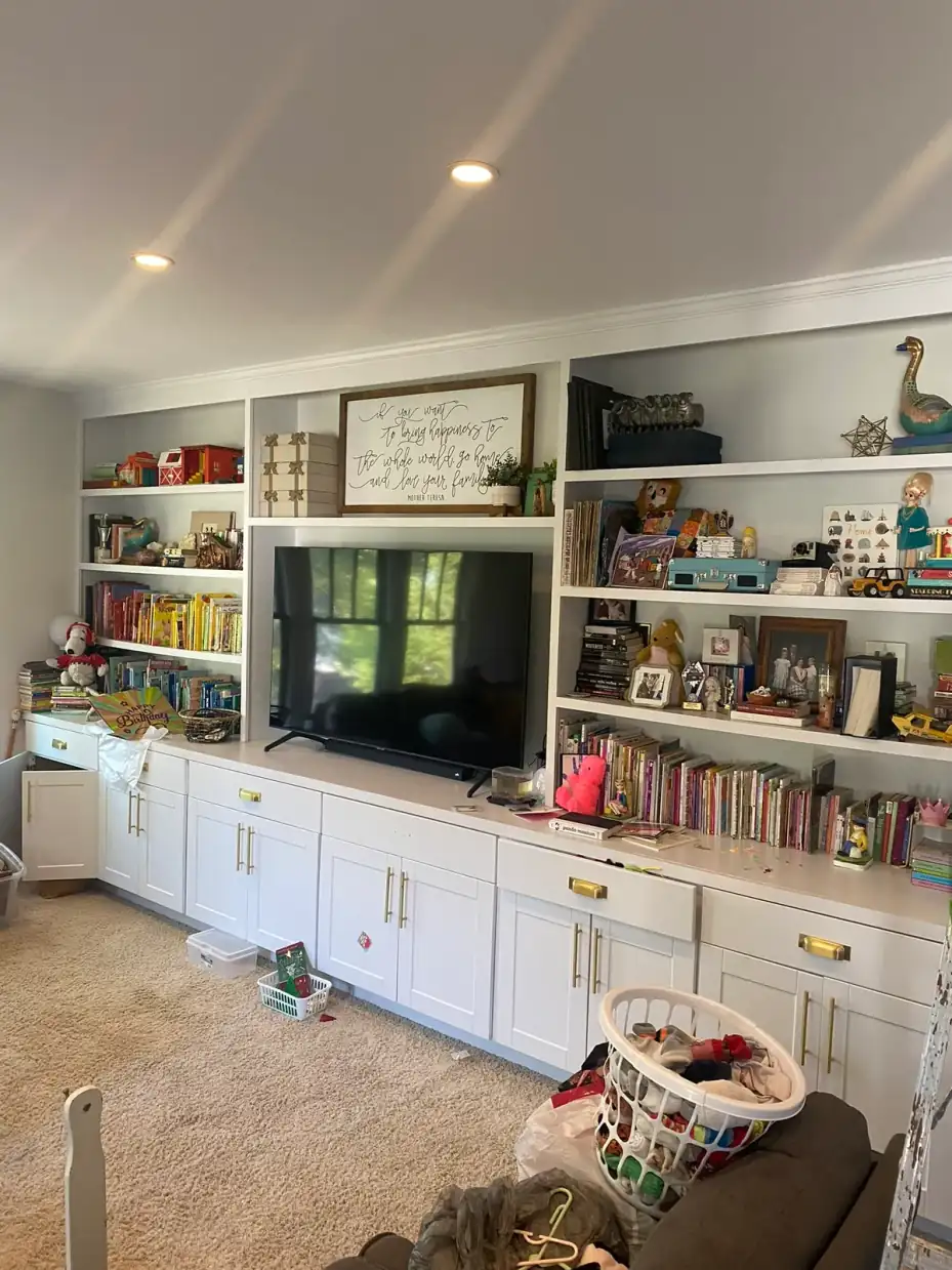 Wall of built-in bookshelves and lower cabinets painted white, part of the cabinet painting we do for Bellevue homes