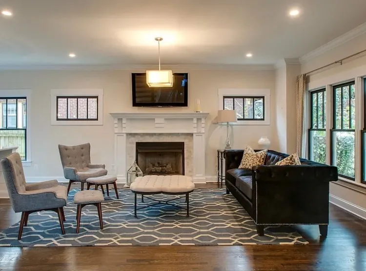 Living room with soft gray walls, windows on three sides and a white-painted mantel, part of the interior painting we do for Belle Meade homes
