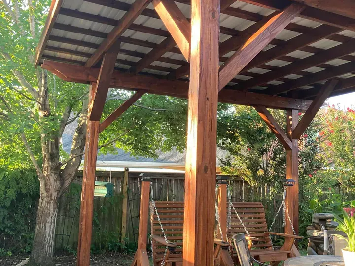 Covered pergola with stained beams over a garden swing, part of the exterior wood staining we do for Belle Meade homes