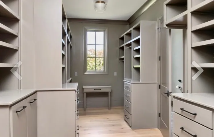 Painted built-in cabinets and shelving beside a small window, one of our cabinet painting projects for Fairview homes