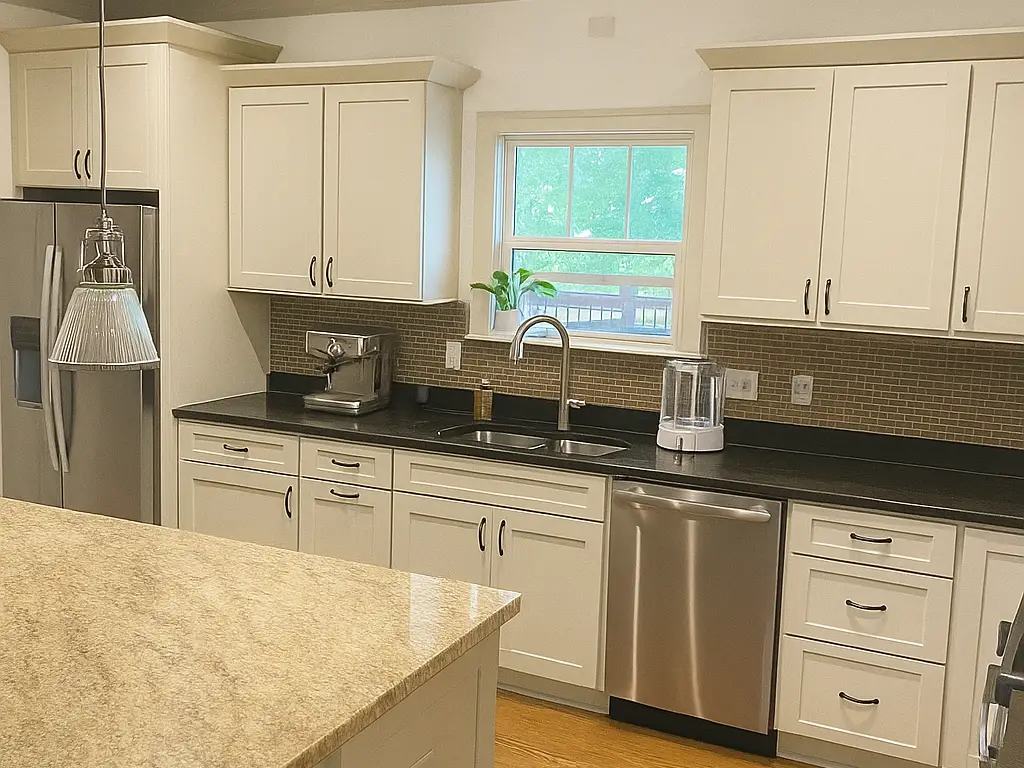 Cream shaker kitchen cabinets and drawers beside a dark stone countertop, cabinet painting for a Belle Meade home