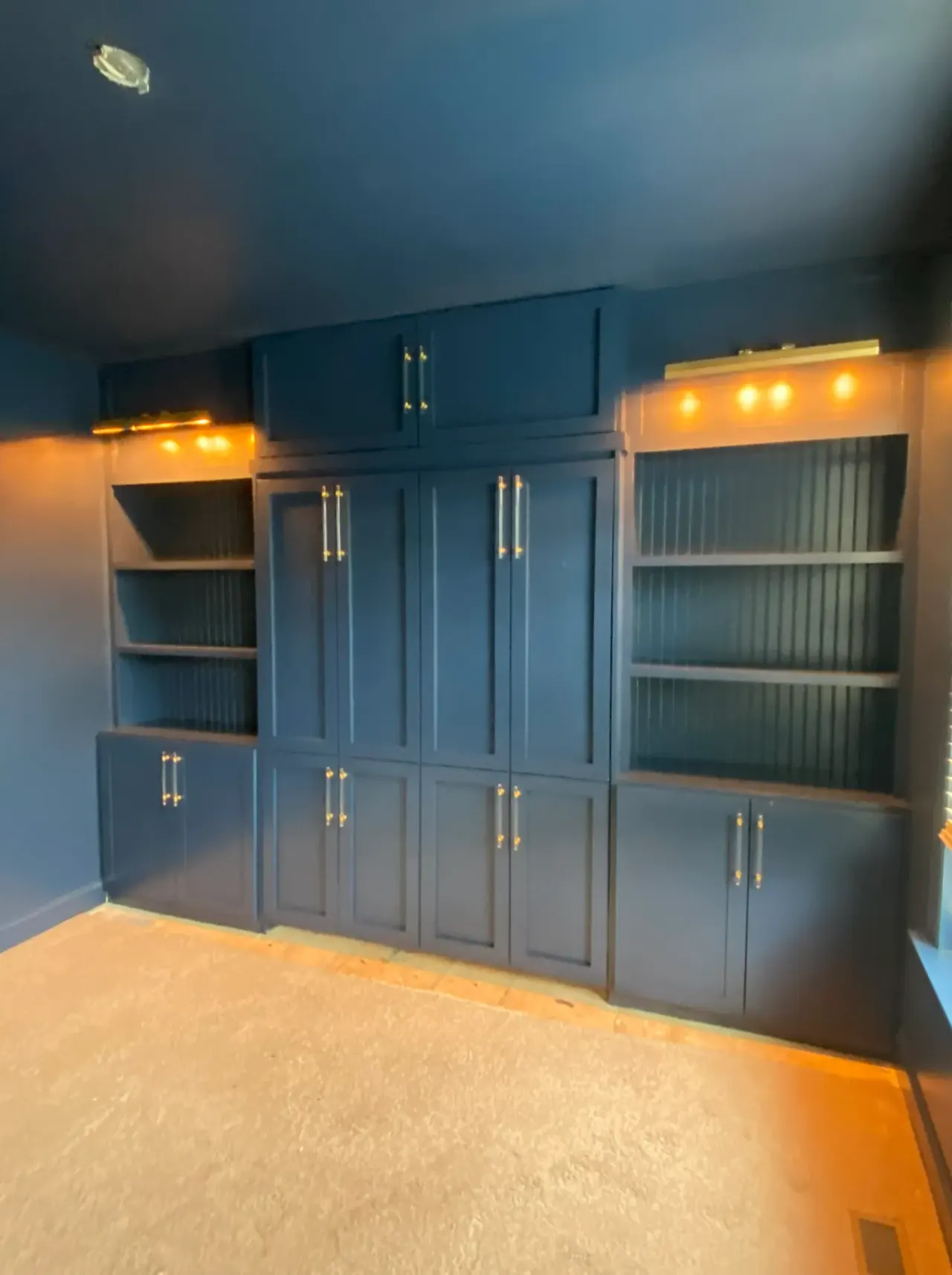 Built-in cabinets and shelving painted a rich navy blue, one of our cabinet painting projects for Belle Meade homes