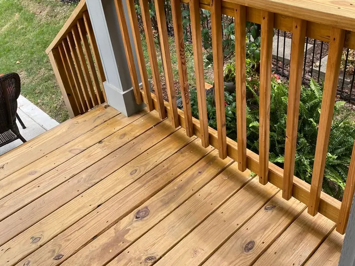 Freshly stained deck railing with square balusters along the deck boards, one of our deck staining projects for Bellevue homes