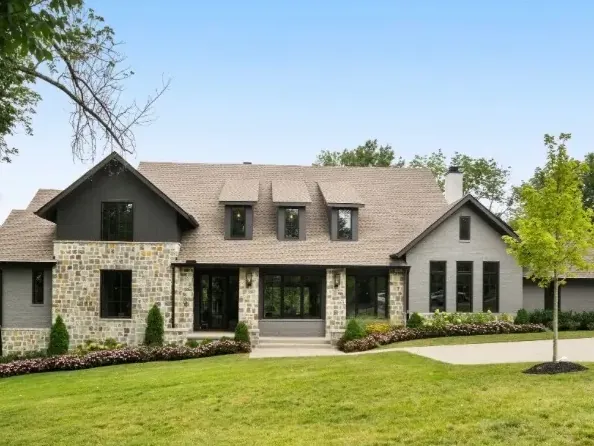 Stone home with dark-painted siding, black windows and painted trim, the kind of detail that shapes a Bellevue exterior painting estimate
