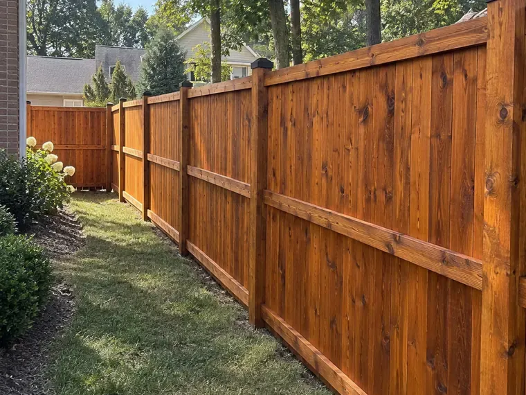 Stained cedar fence showing both faces, the rail side and the picket side, the kind of detail that shapes a Bellevue fence staining estimate