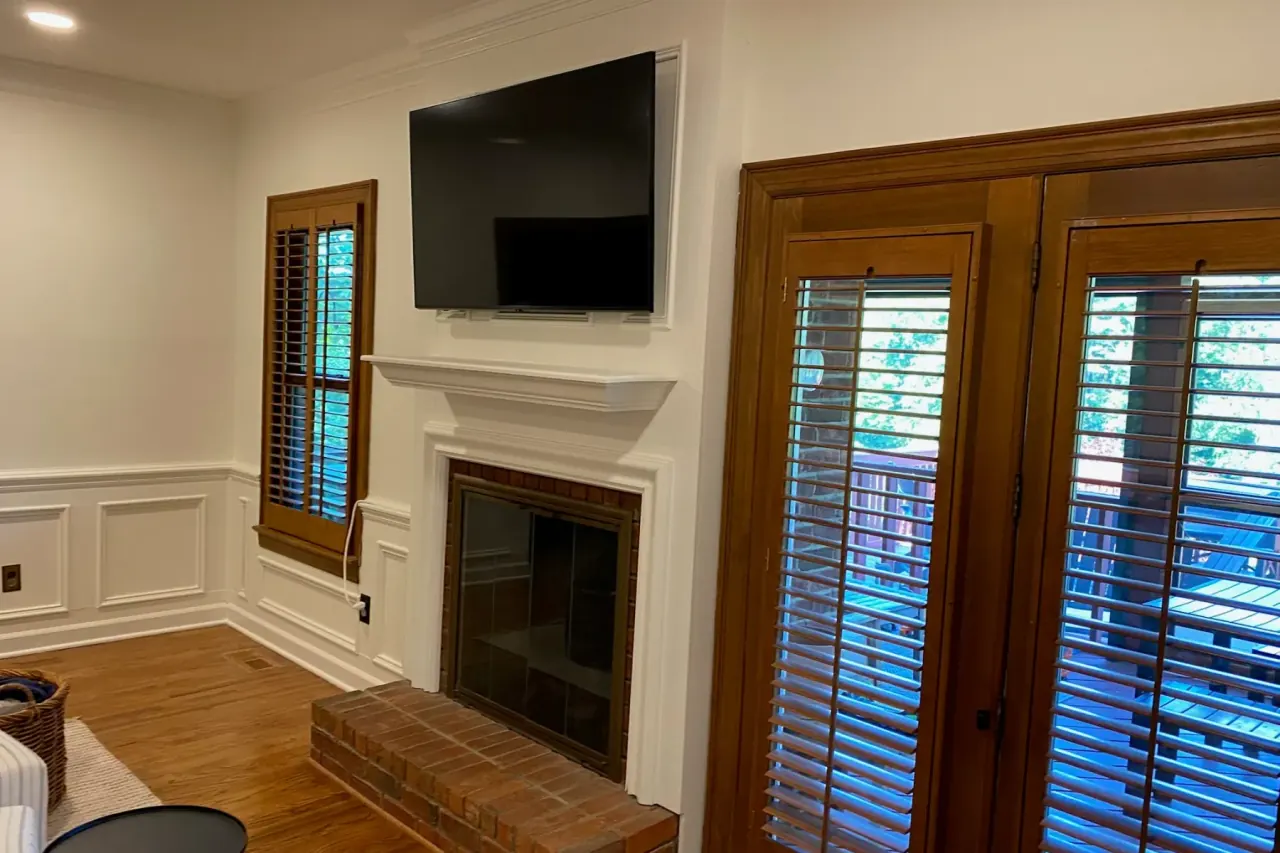 Living room with painted wainscoting and crown molding around a fireplace and French doors, the kind of detail that shapes a Bellevue interior painting estimate