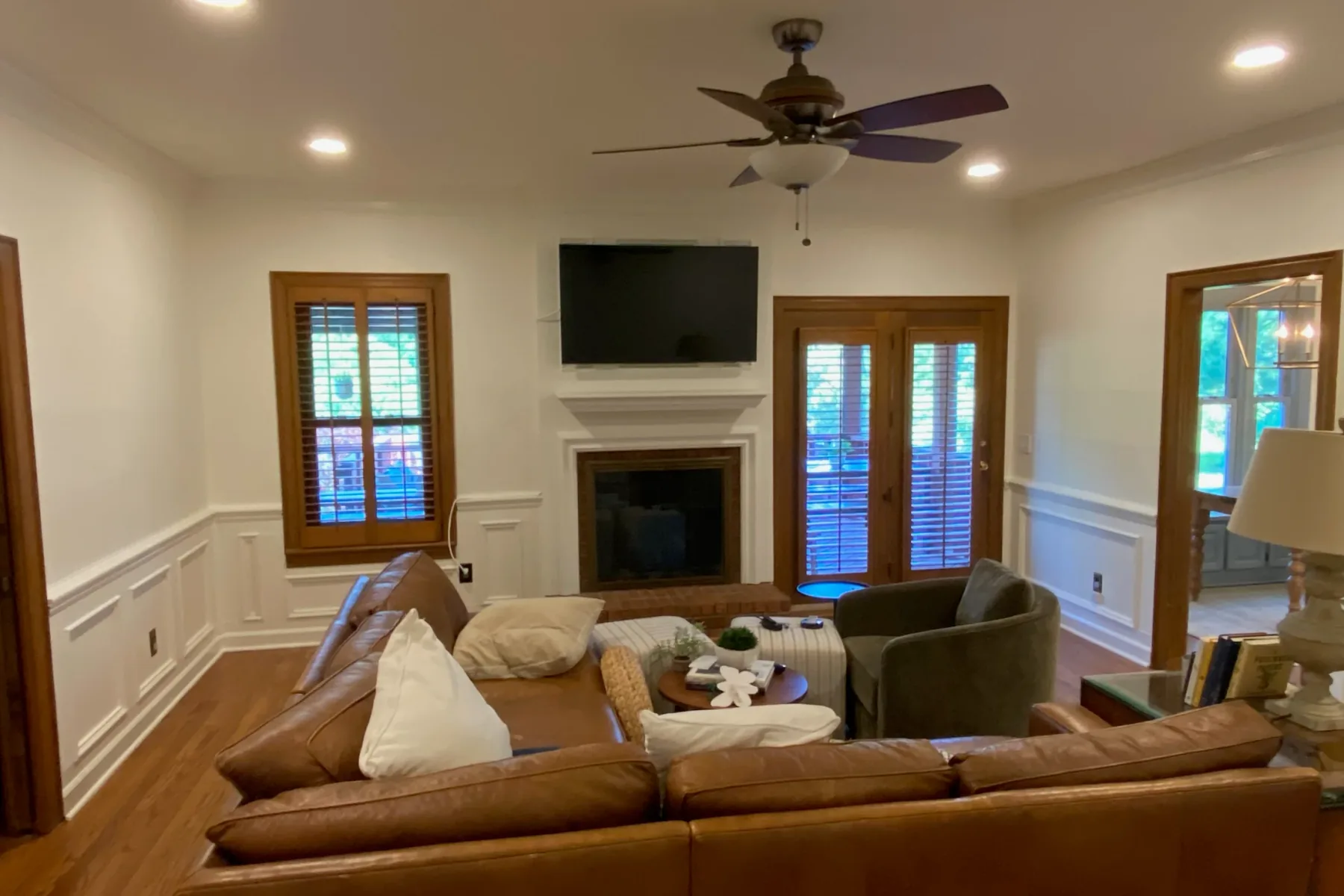 Living room with wainscoting, crisp white trim and a painted fireplace surround, a step in our interior painting process for Bellevue homes
