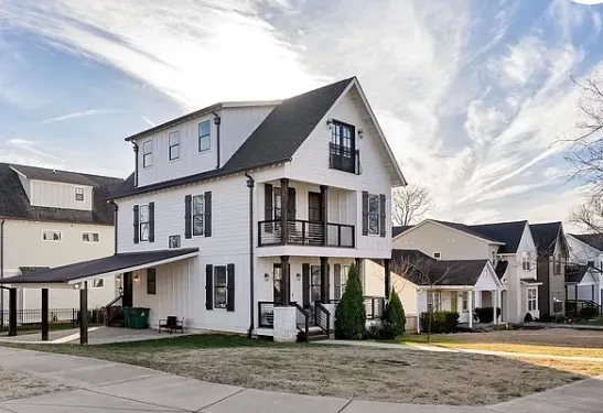 White farmhouse-style home with black shutters — painted trim by Alan Robinson