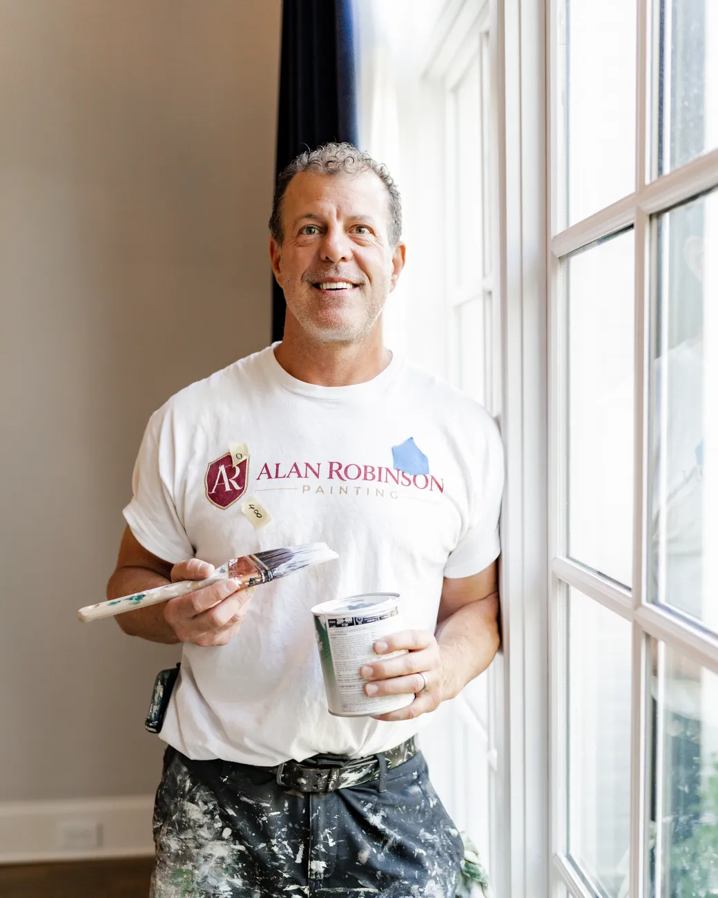 Alan Robinson, house painter and fine artist, holding a brush and a paint can, Alan Robinson Painting in Bellevue