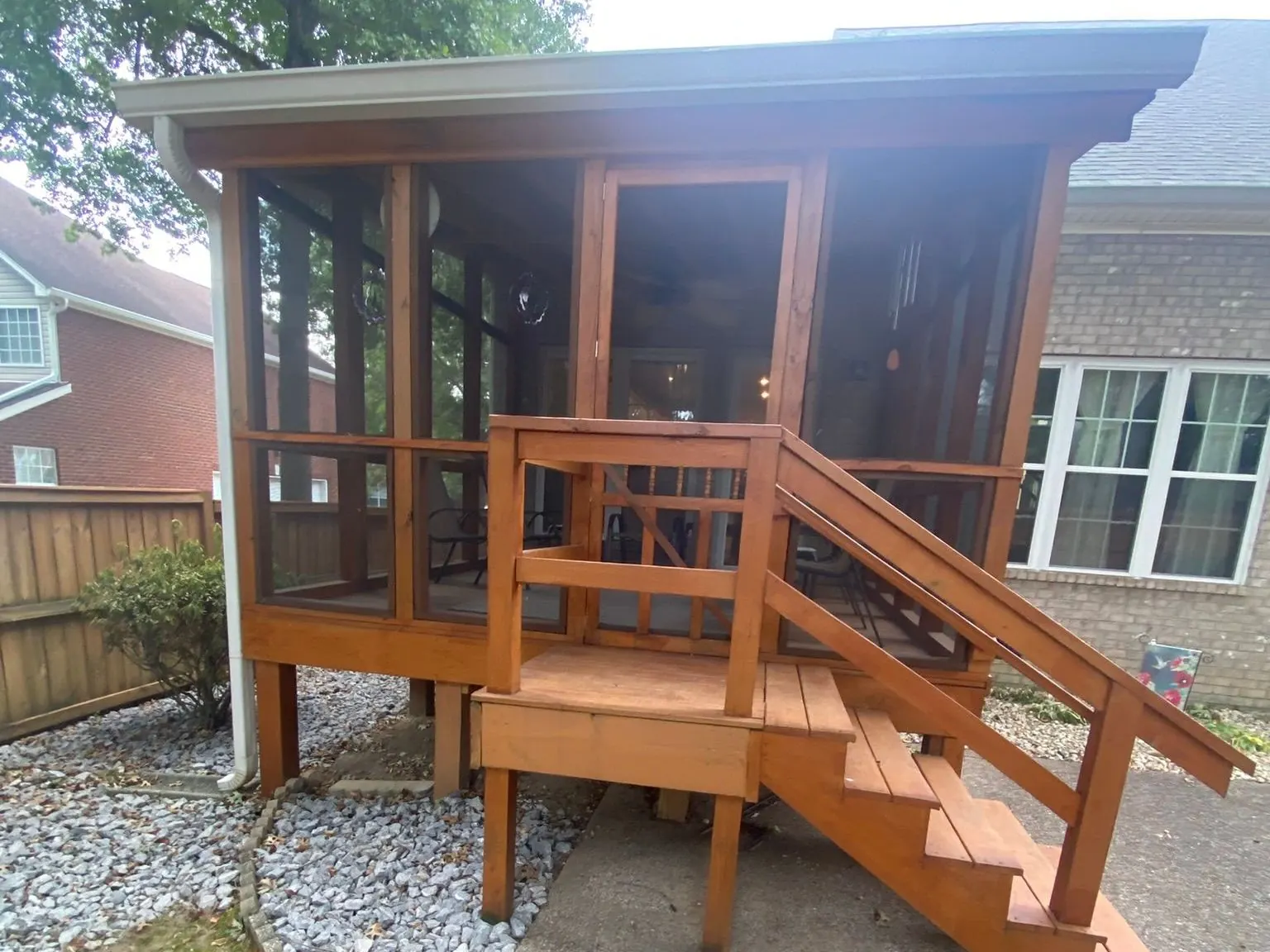 Stained deck and screened porch with a stair down to a concrete patio, deck staining for Brentwood homes