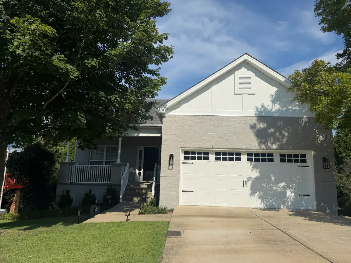 Home with gray-painted brick, a white board-and-batten gable and white trim, part of the exterior painting we do for Bellevue homes
