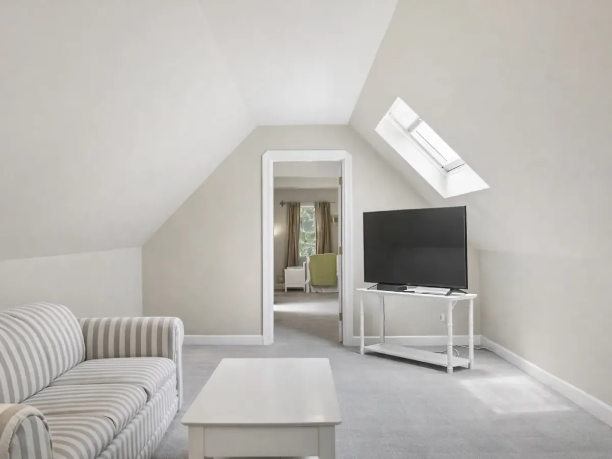 Upstairs bonus room with sloped ceilings, a skylight and pale painted walls, interior painting for Fairview homes