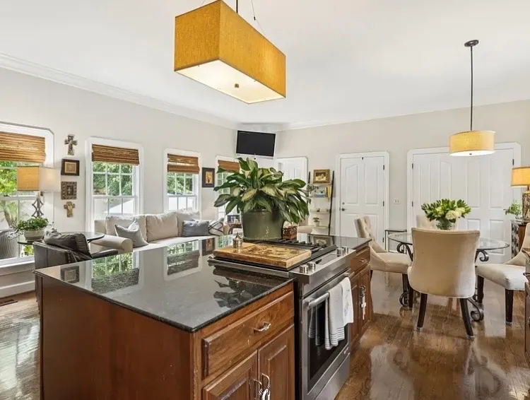 Open kitchen and dining area with fresh paint beside warm wood cabinetry, interior painting for a Bellevue home