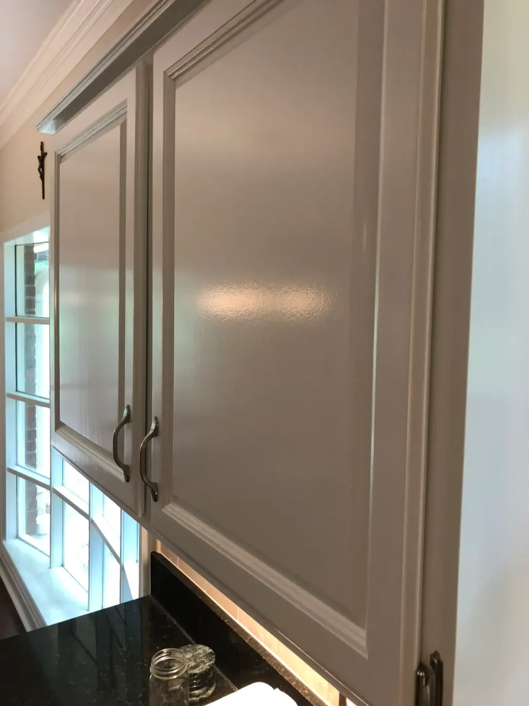 Close-up of a painted upper cabinet door with a smooth, even finish, a step in our cabinet painting process for Bellevue homes