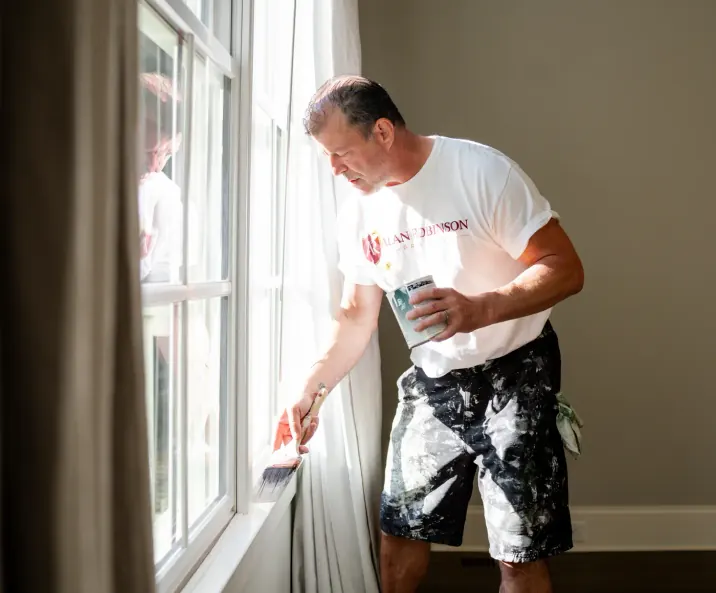 Painter brushing out a freshly primed window casing, a step in our interior painting process for Bellevue homes
