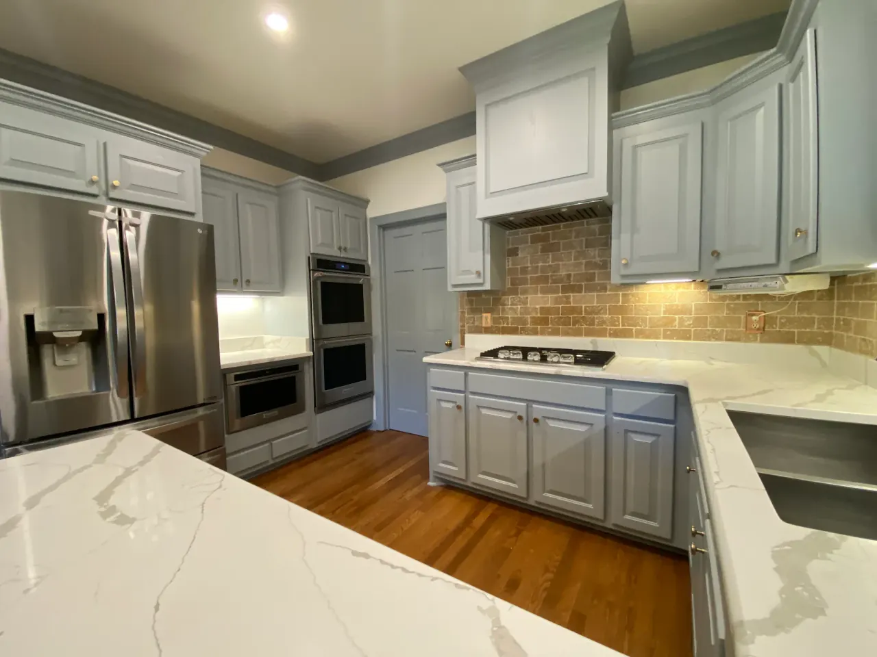 Abigail W.'s kitchen cabinets and island painted gray, a customer photo from a Google review
