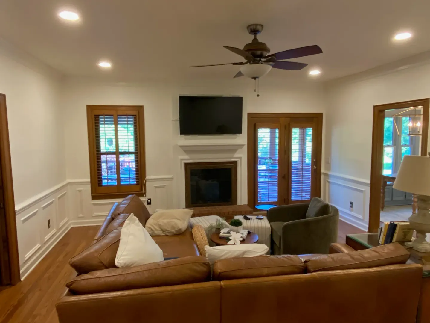 Abigail W.'s living room with fresh paint and white wainscoting around the fireplace, part of the interior painting we do for Brentwood homes